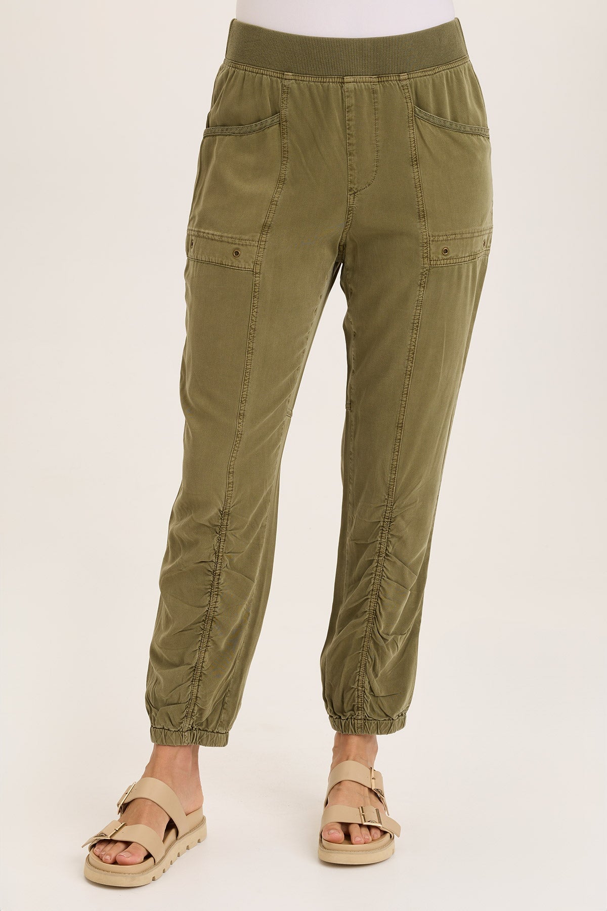 Olive green cargo pants worn by a person on a white background