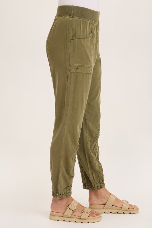 Olive green pants worn by a person on a white background
