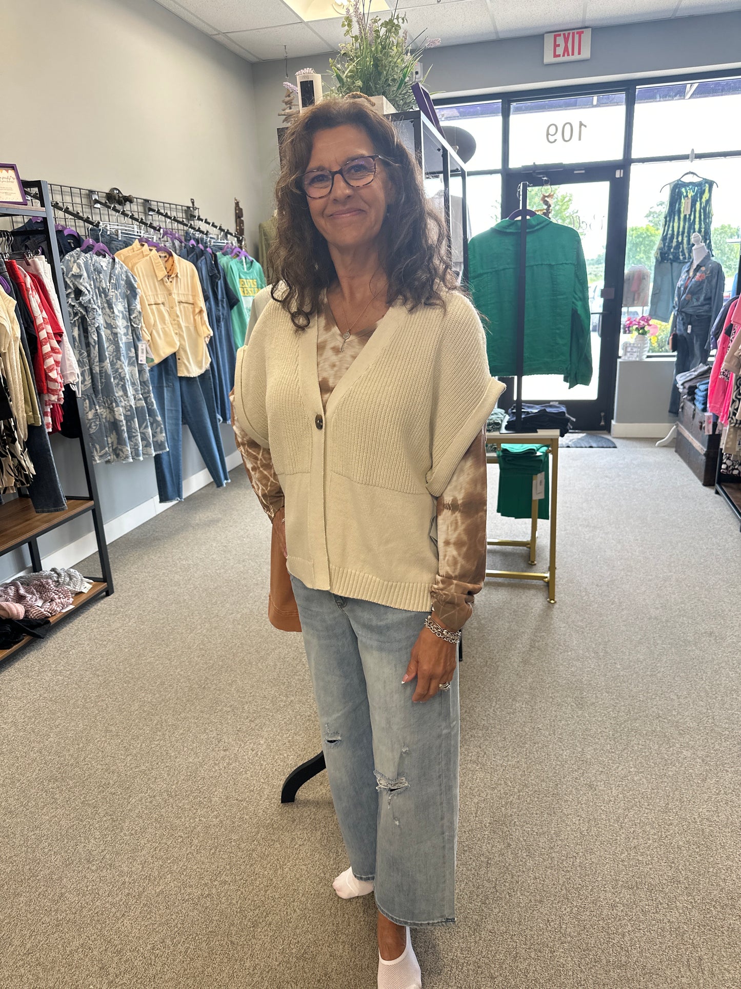 Woman standing in a store with racks of clothing in the background