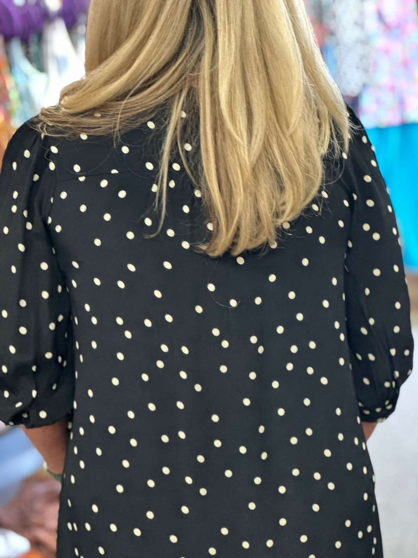 Its black with tan polka dots, pockers, 3/4 sleeve with a little ruching at the top of the v-neck.