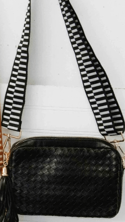 Our Woven Willow Camera Crossbody Bag is the perfect outfit completer. This vegan leather bag has fun straps with a block design. The Woven Willow has gold hardware with a zippered top, a beige and black chevron interior, and a zippered stash pocket on the inside.