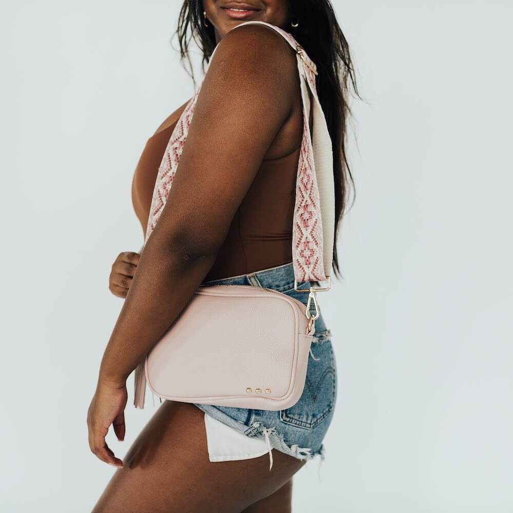 You are going to love this style. This is the perfect bag to hold all your things with a small front pocket for your smaller easy to reach items such as keys, lipgloss, hair ties, etc. The large side pocket has a chevron pattern, and an additional slash zipper pocket. The Austin Sling Bag has a removable woven floral guitar strap, and is a great bag for many occasions.
