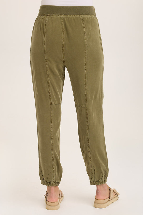 Olive green pants worn by a person on a white background