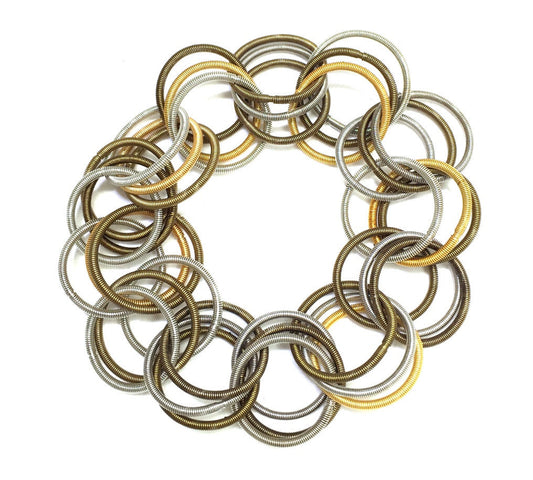Set of metal springs in gold, silver, and bronze on a white background