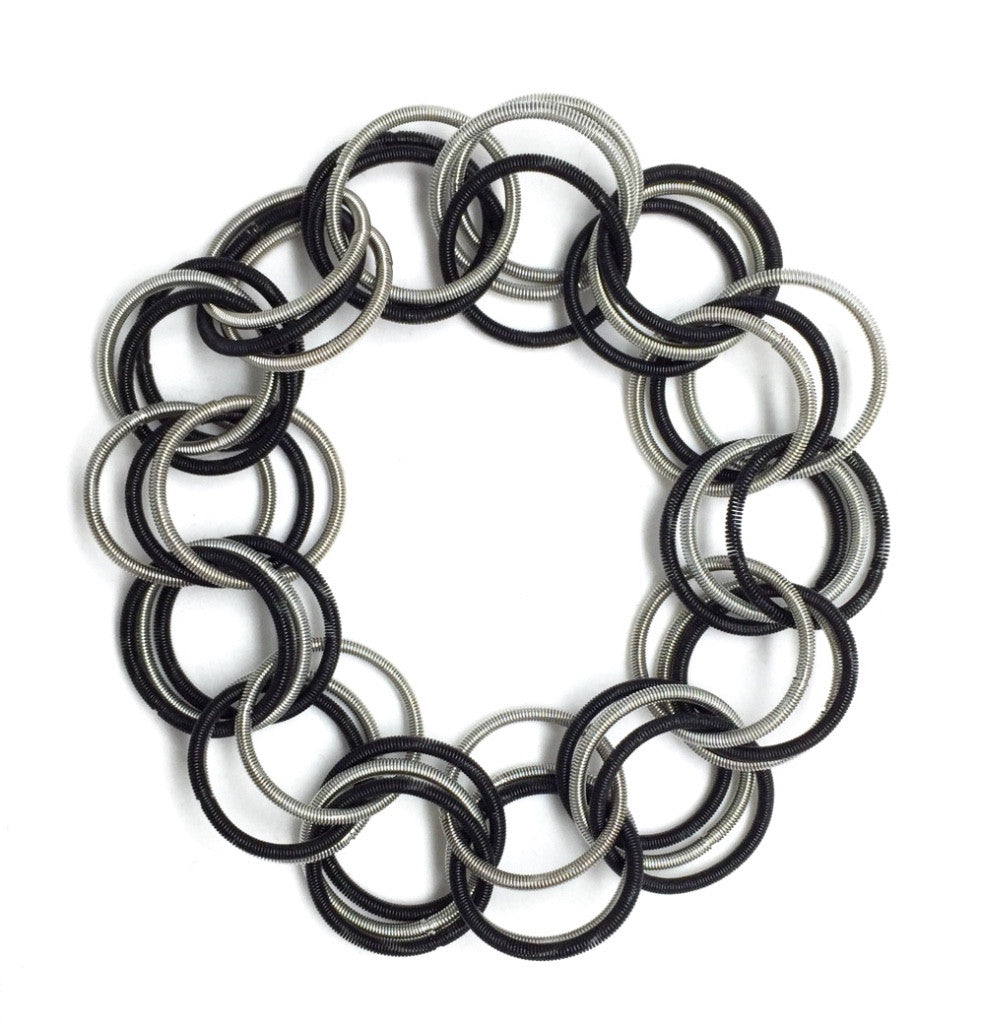 Wreath made of interlocking black and silver rings on a white background