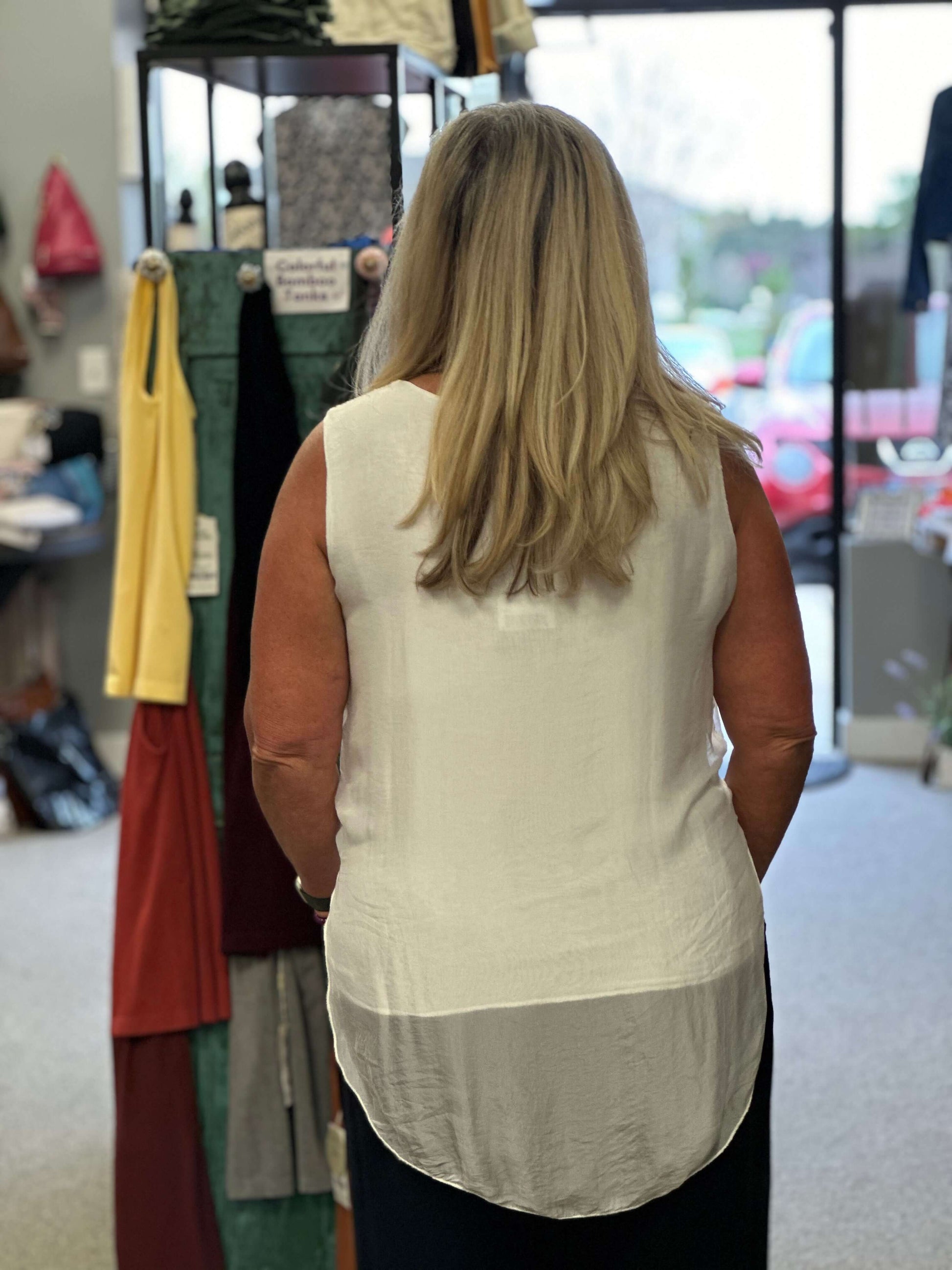 This white sleeveless beauty will go with anything in your wardrobe. You can wear it with jeans or a night on the tow, it's that versatile. The cami is build inside and the overlay is longer in the front and back.