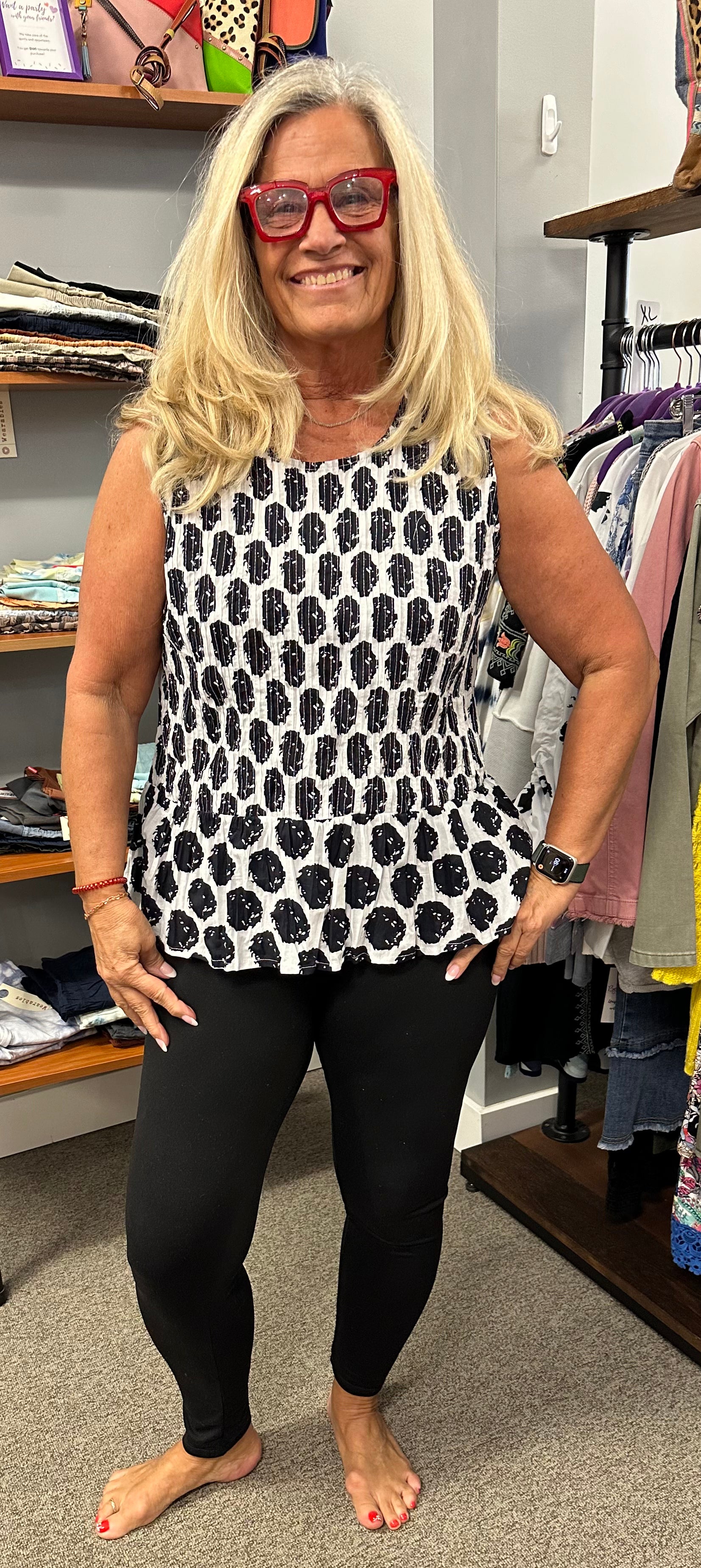 Black and white always looks good any time of year. This sleeveless top has a slight ruffle just below the waist to add a little flair to the look.