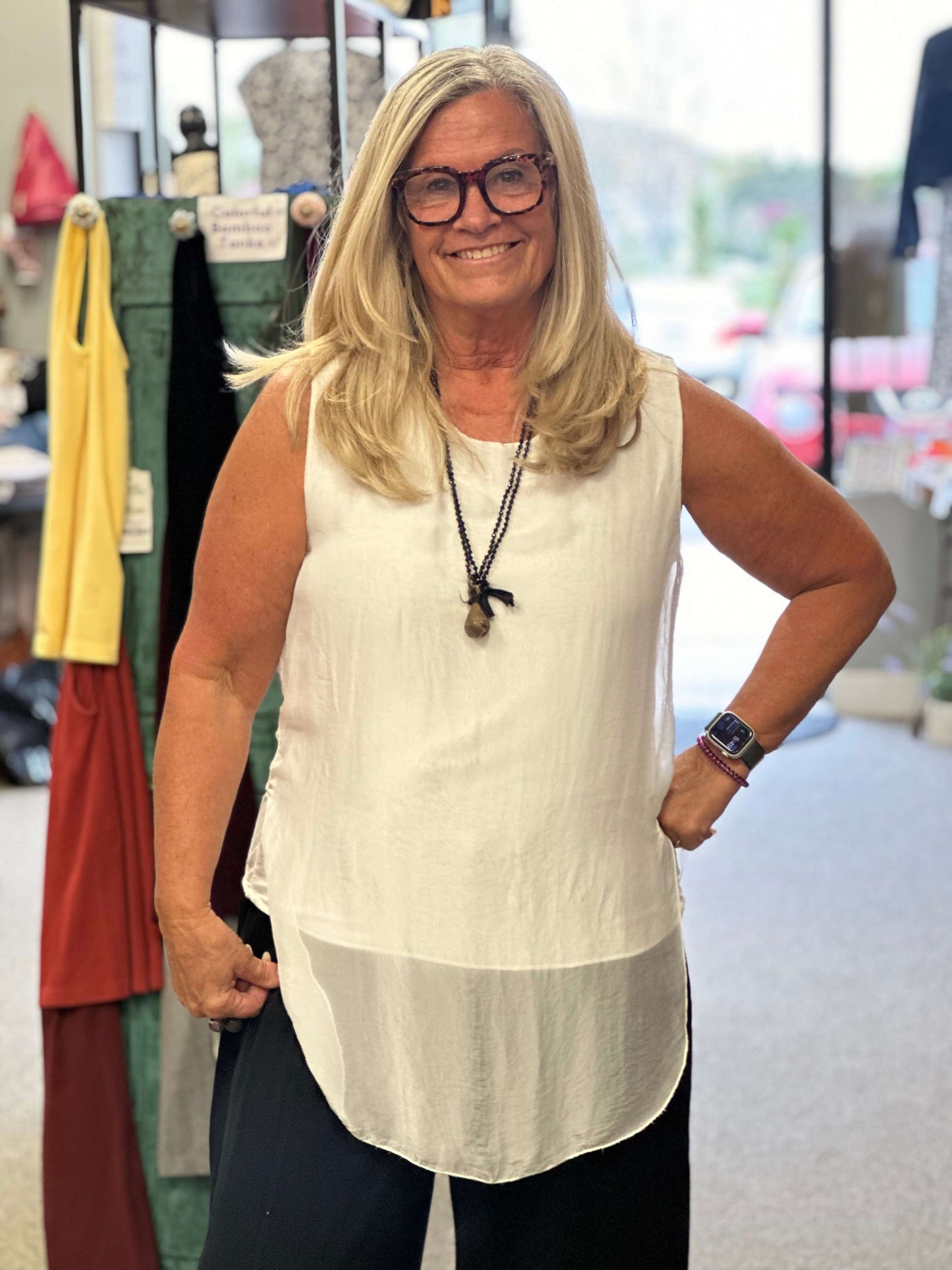 This white sleeveless beauty will go with anything in your wardrobe. You can wear it with jeans or a night on the tow, it's that versatile. The cami is build inside and the overlay is longer in the front and back.