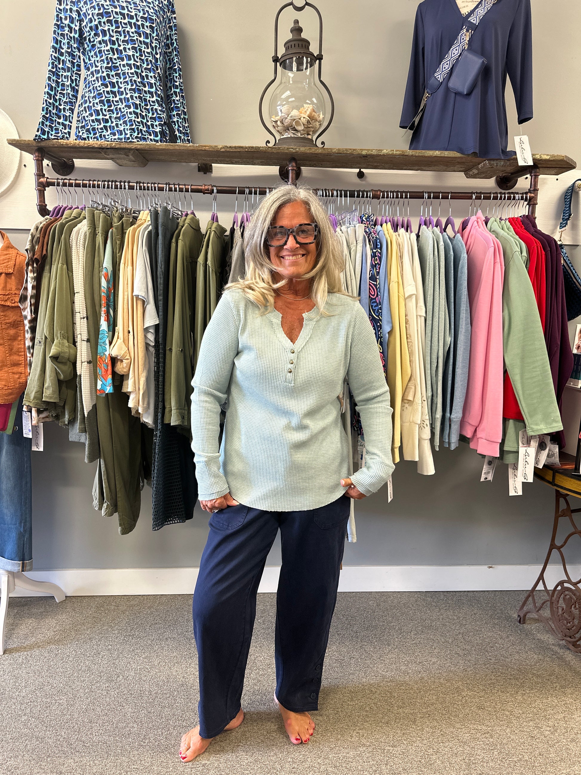 Person standing between racks of fabric swatches in a fabric store