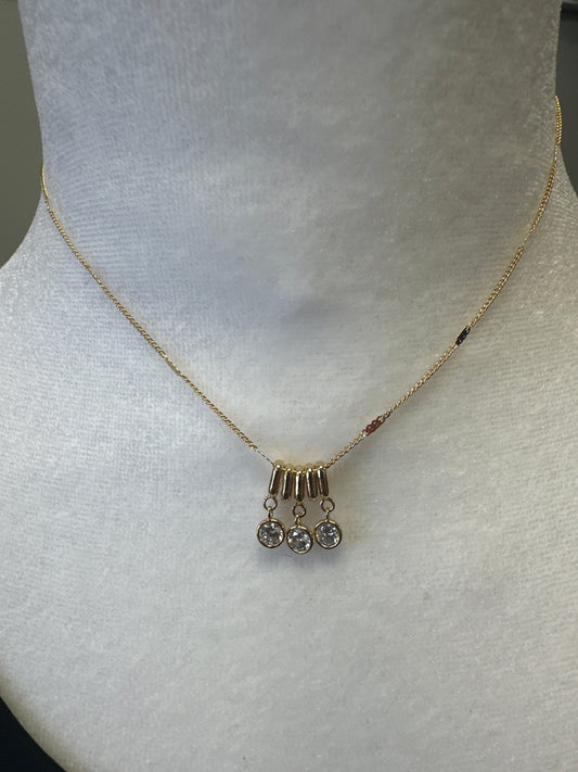 Gold necklace with small beads on a light gray background